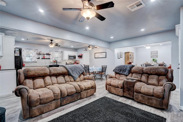 living room featuring light wood-type flooring and ceiling fan