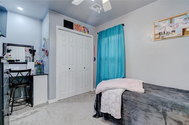 carpeted bedroom featuring ceiling fan and a closet