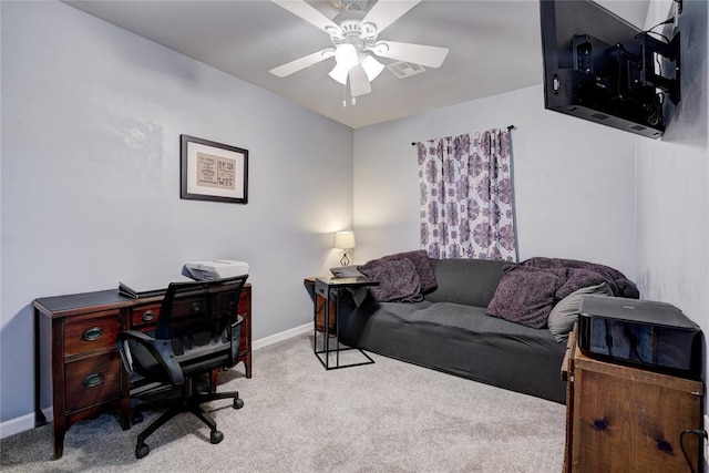 carpeted home office featuring ceiling fan