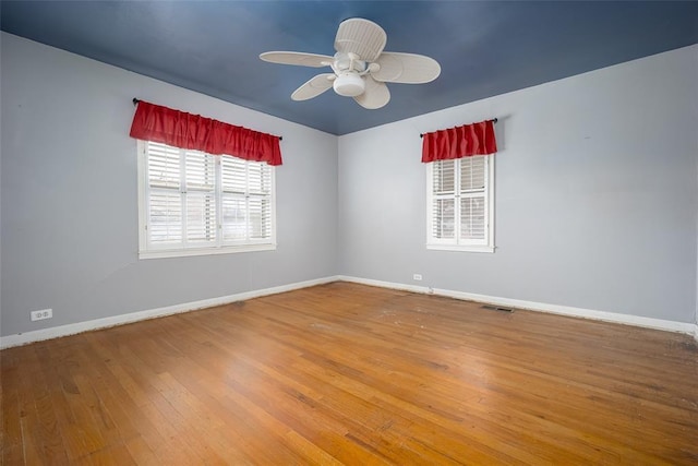 empty room with hardwood / wood-style floors and ceiling fan