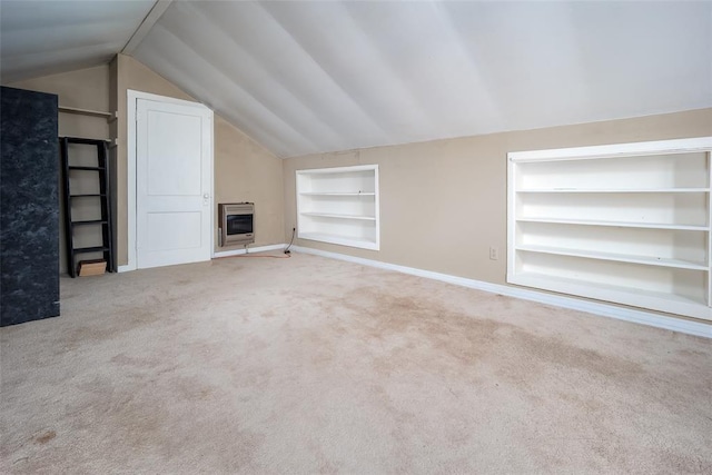 unfurnished living room featuring heating unit, built in shelves, carpet floors, and lofted ceiling