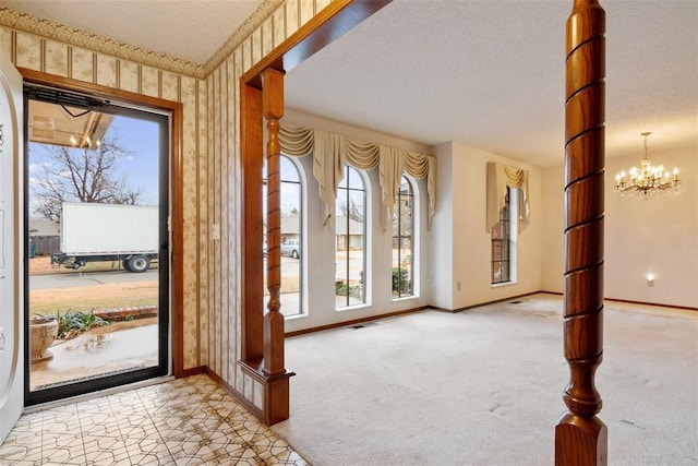 entryway with an inviting chandelier, light colored carpet, and a textured ceiling