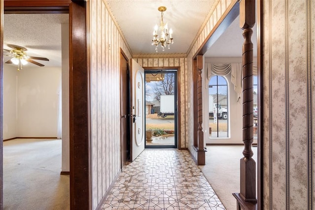 doorway to outside with light carpet, ceiling fan with notable chandelier, and a textured ceiling