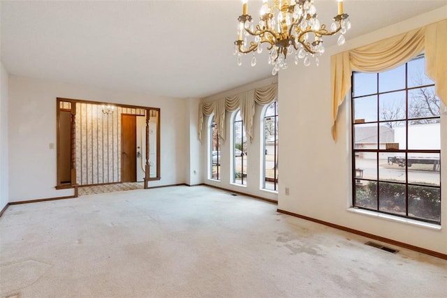 carpeted spare room featuring a chandelier