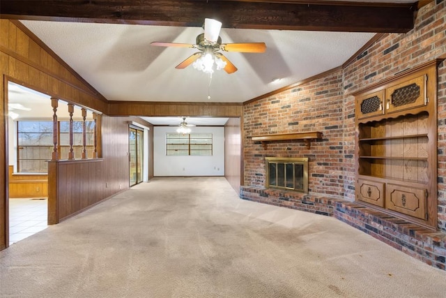 unfurnished living room with lofted ceiling with beams, a brick fireplace, light colored carpet, and wooden walls