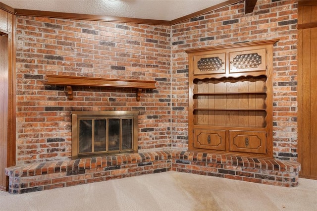 unfurnished living room featuring a fireplace, carpet floors, and a textured ceiling