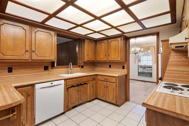 kitchen with sink, white appliances, range hood, decorative light fixtures, and a chandelier