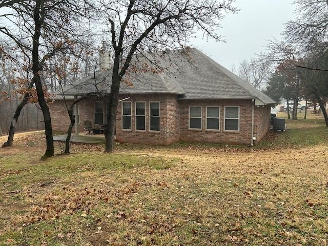 view of side of property featuring a yard and central AC unit