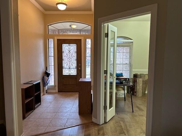 entrance foyer featuring crown molding and light hardwood / wood-style flooring