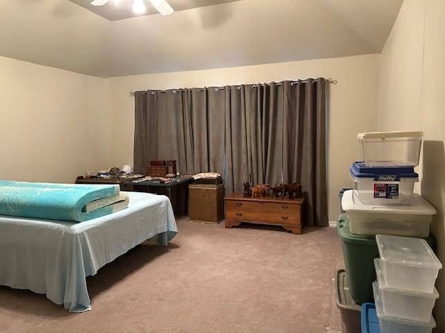 bedroom with ceiling fan, carpet floors, and vaulted ceiling