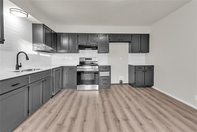 kitchen featuring gray cabinets, appliances with stainless steel finishes, tasteful backsplash, sink, and light hardwood / wood-style floors