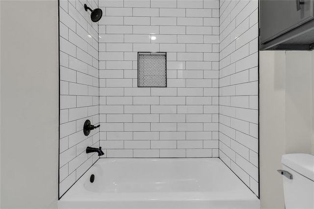 bathroom featuring tiled shower / bath and toilet