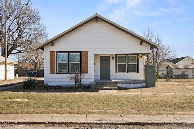 bungalow-style home with a front yard