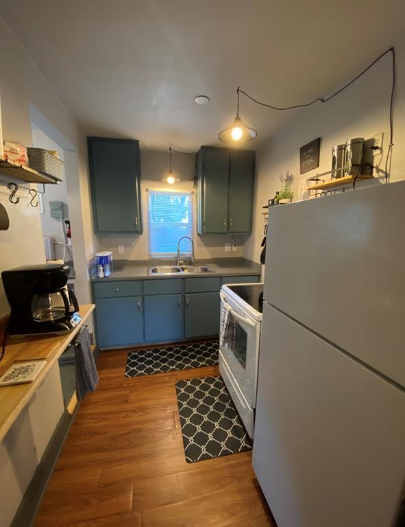 kitchen featuring dark hardwood / wood-style floors, sink, and white appliances