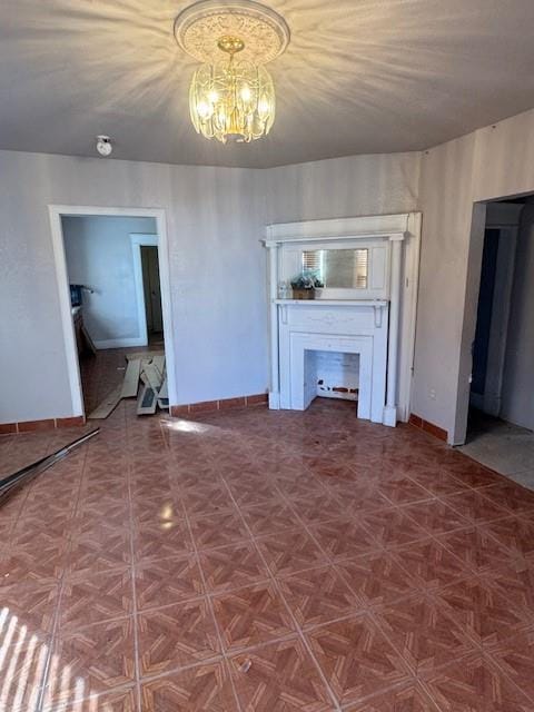 unfurnished living room with an inviting chandelier and a fireplace