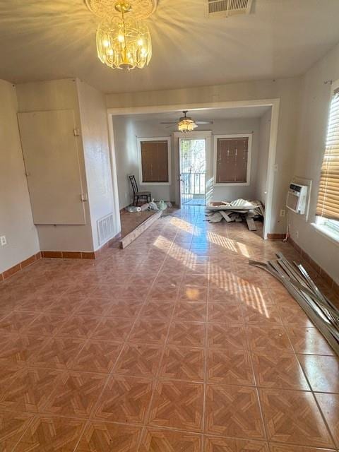 interior space with parquet floors, ceiling fan with notable chandelier, and a wall unit AC