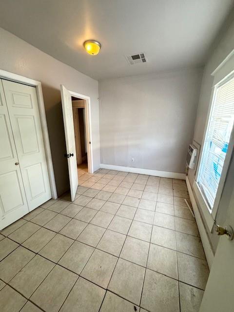 unfurnished bedroom with a closet and light tile patterned flooring