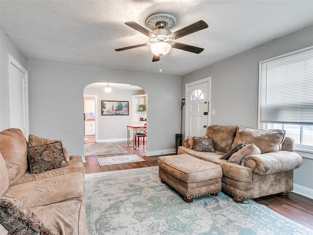 living room with hardwood / wood-style floors, a textured ceiling, and ceiling fan