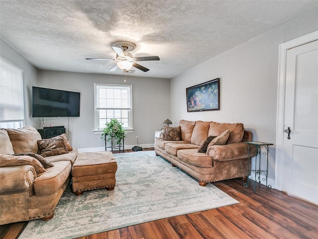 living room with ceiling fan, dark hardwood / wood-style floors, and a textured ceiling