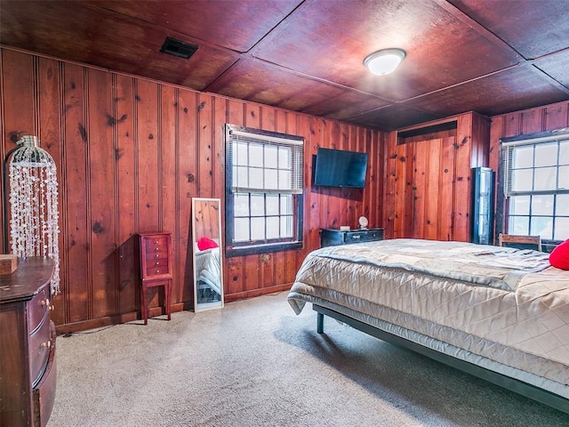 carpeted bedroom featuring wood walls