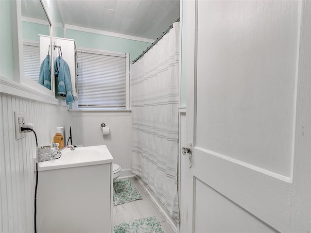 bathroom with vanity, ornamental molding, toilet, and walk in shower