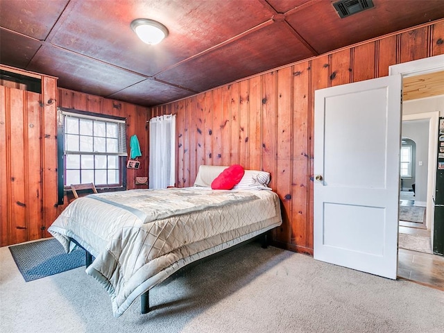 bedroom with wooden walls and carpet