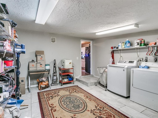 clothes washing area with light tile patterned floors, a textured ceiling, and independent washer and dryer