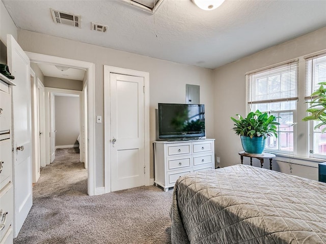 bedroom with light carpet and a textured ceiling