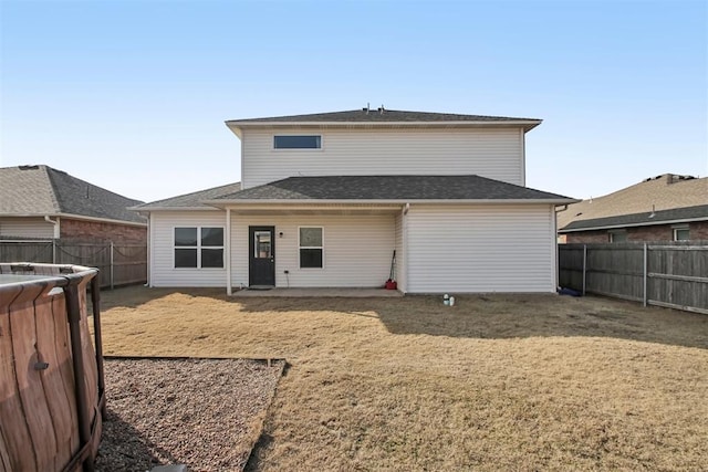 rear view of property featuring a lawn