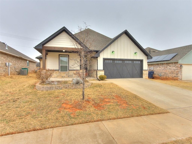 view of front of property featuring a garage, central AC, a front lawn, and a porch