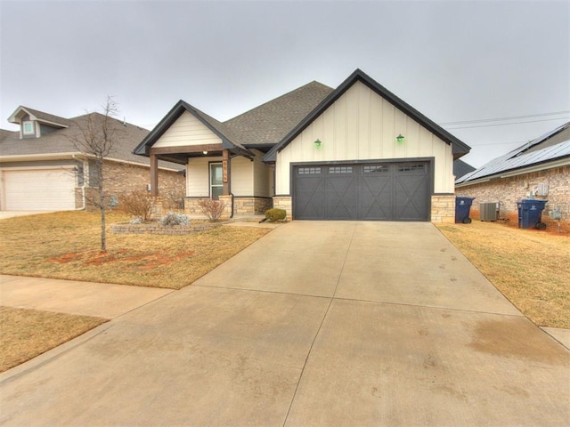 view of front of house with cooling unit, a garage, a front lawn, and covered porch