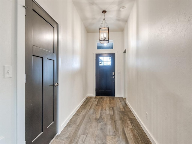 entryway featuring wood-type flooring and a chandelier