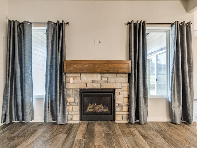 room details featuring a stone fireplace and hardwood / wood-style floors