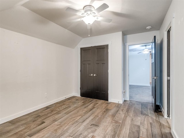 unfurnished bedroom with vaulted ceiling, ceiling fan, light hardwood / wood-style floors, and a closet