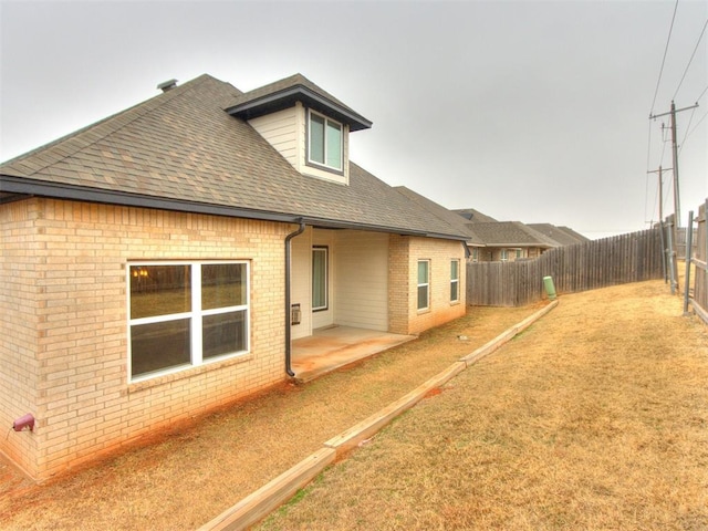 rear view of property with a patio and a lawn