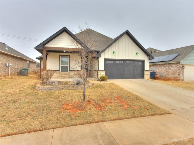 8909 NW 129th St, Oklahoma City, OK 73142 - ranch-style home featuring board and batten siding, covered porch, central air condition unit, a front yard, and an attached garage