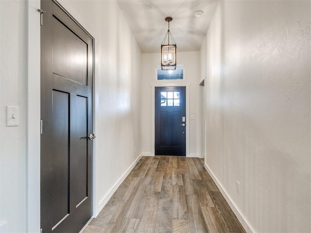 8909 NW 129th St, Oklahoma City, OK 73142 - entryway featuring a chandelier, wood finished floors, and baseboards