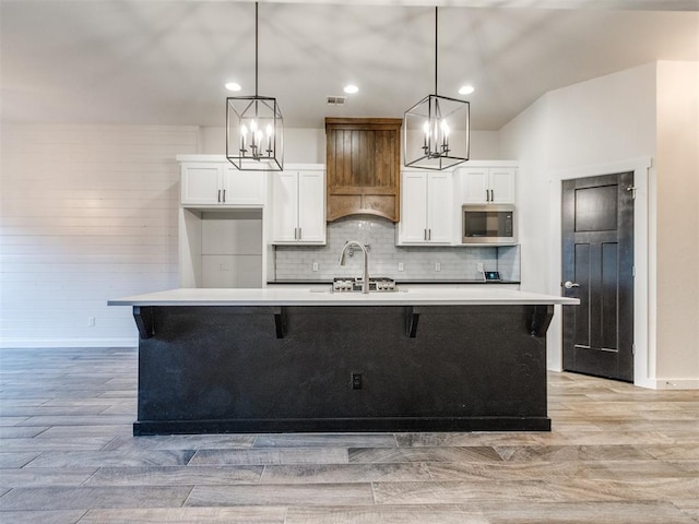 8909 NW 129th St, Oklahoma City, OK 73142 - kitchen with stainless steel microwave, a chandelier, white cabinets, and recessed lighting