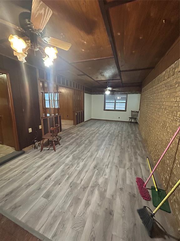 basement featuring hardwood / wood-style flooring and brick wall