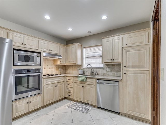 kitchen with light tile patterned flooring, appliances with stainless steel finishes, sink, and decorative backsplash