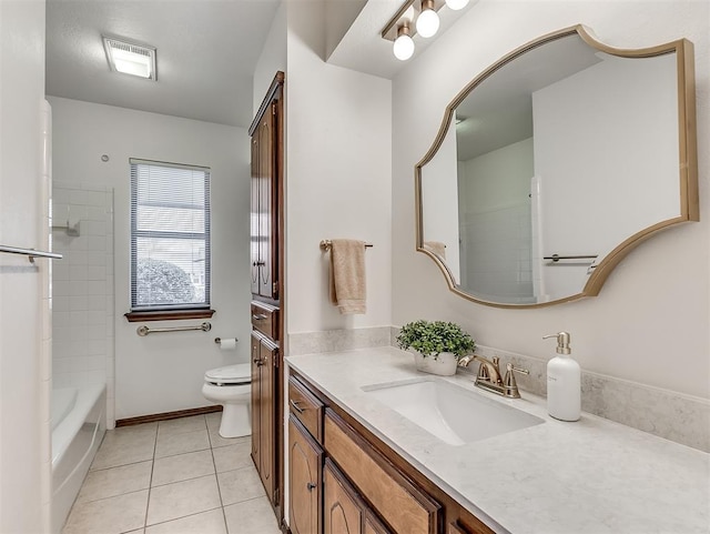 full bathroom featuring tile patterned flooring, vanity, tiled shower / bath, and toilet