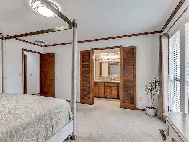 carpeted bedroom with crown molding, sink, and connected bathroom