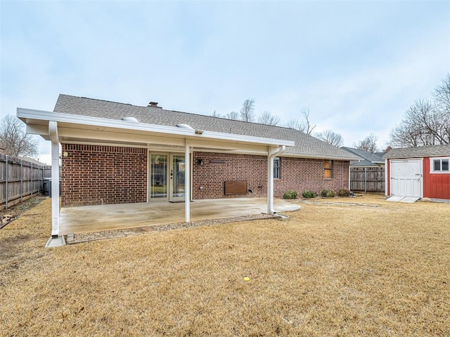 back of property featuring a storage shed, a patio, and a lawn