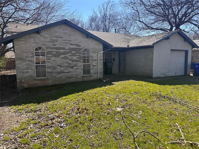 view of front facade featuring brick siding, an attached garage, and a front lawn