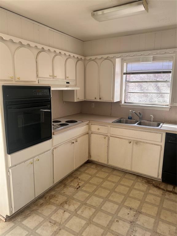 kitchen featuring oven, light floors, white electric cooktop, light countertops, and a sink