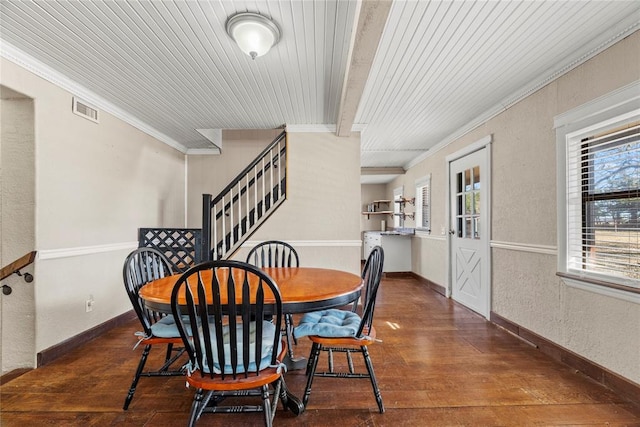 dining area with crown molding, dark wood-type flooring, and beam ceiling