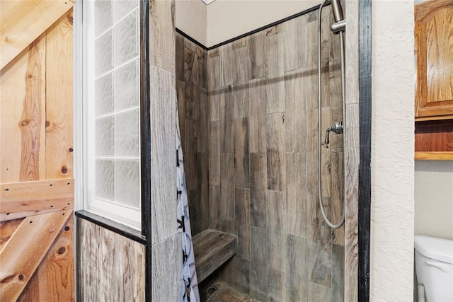 bathroom with tiled shower and toilet