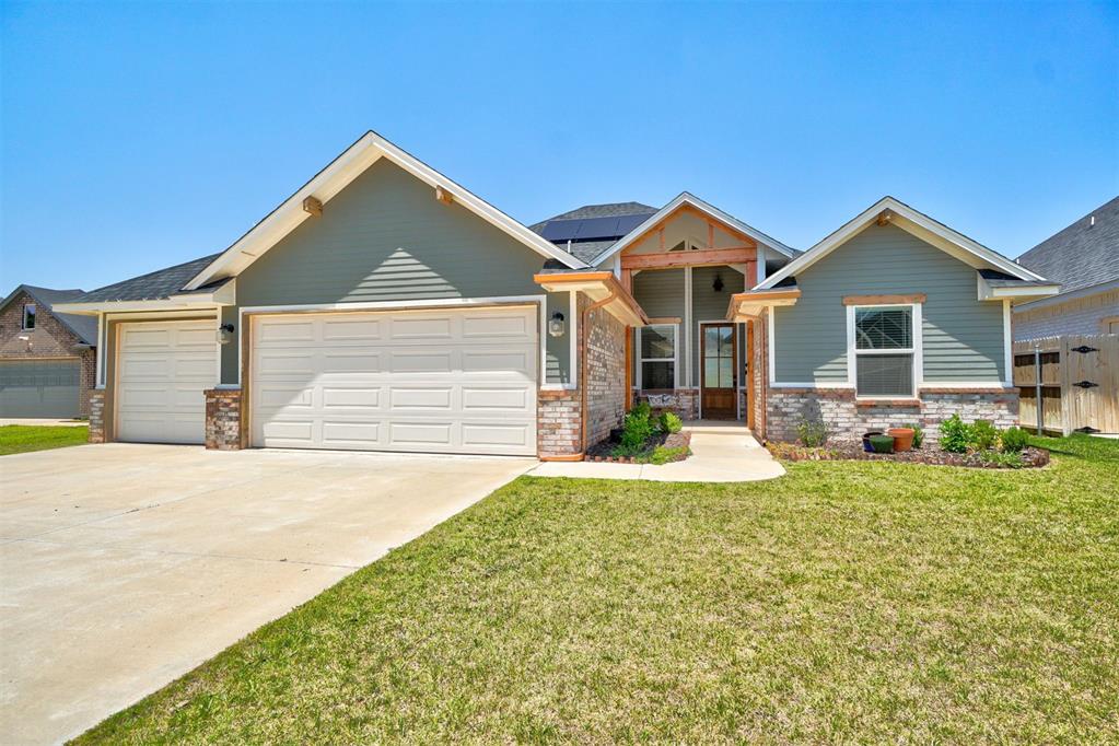 craftsman-style house with a garage, a front yard, covered porch, and solar panels