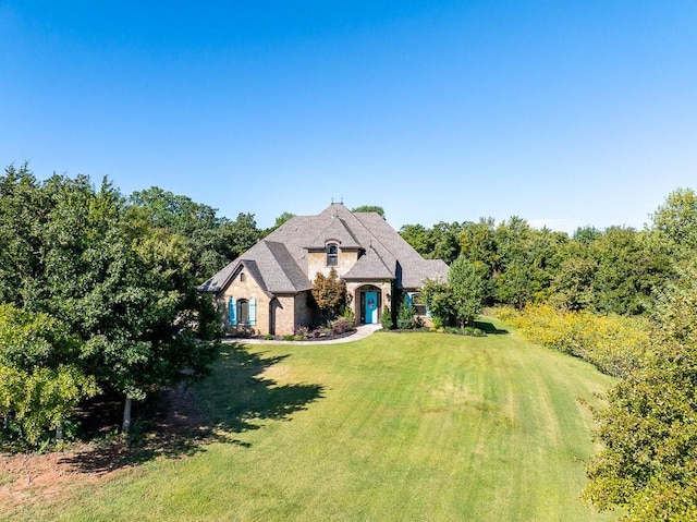 french country home featuring a front yard