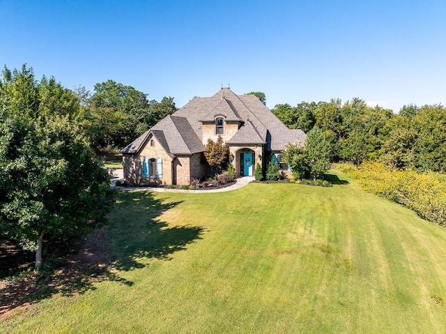 french country style house featuring a front lawn